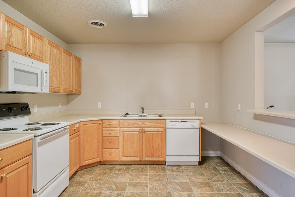 a kitchen with white appliances and wooden cabinets