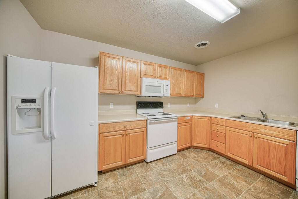 a kitchen with white appliances and wooden cabinets