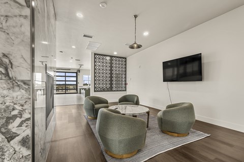 A modern living room with a grey sofa and a TV on the wall.