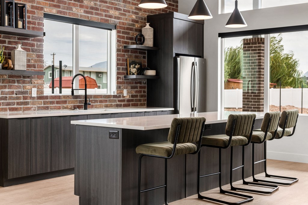 a kitchen with a brick wall and a large island with bar stools