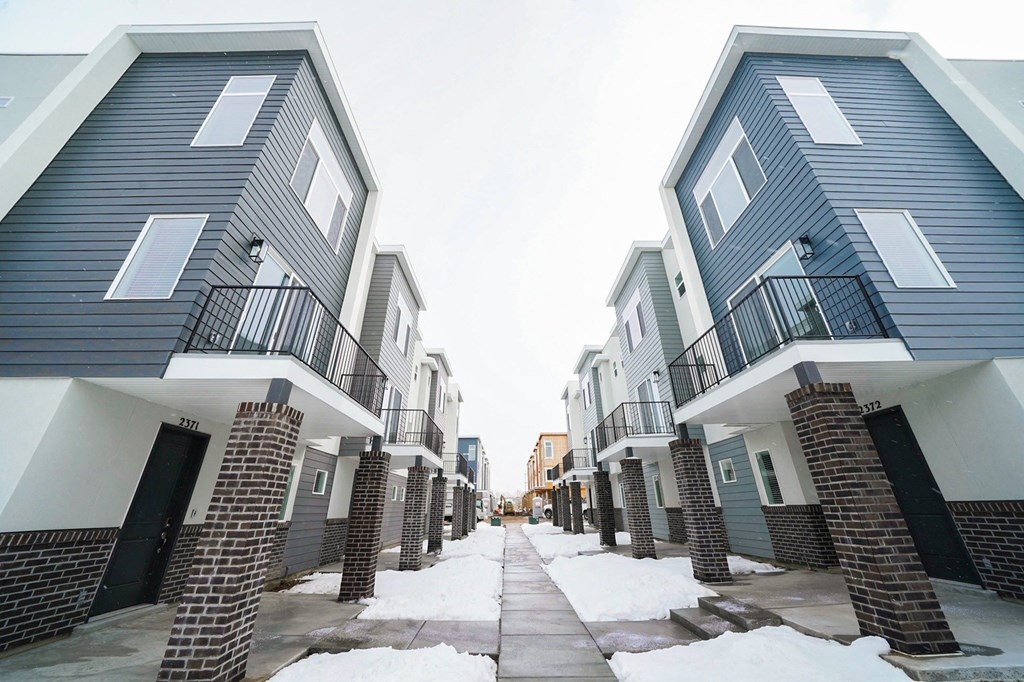an image of an apartment complex with snow on the ground