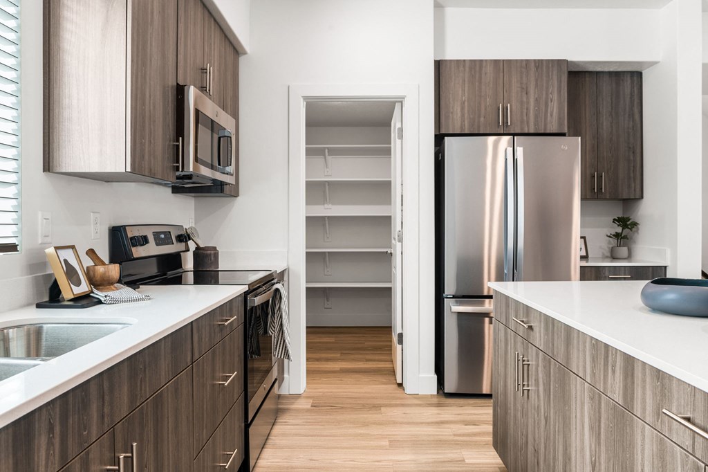 a kitchen with white countertops and wooden cabinets