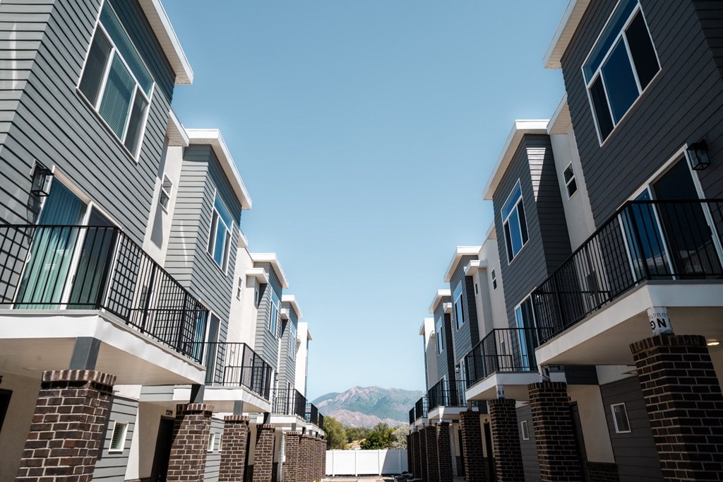 a row of apartment buildings with mountains in the background