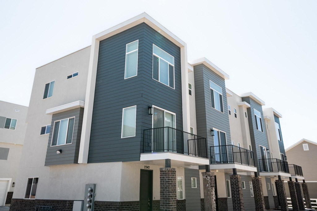 a row of apartment buildings with blue and white siding