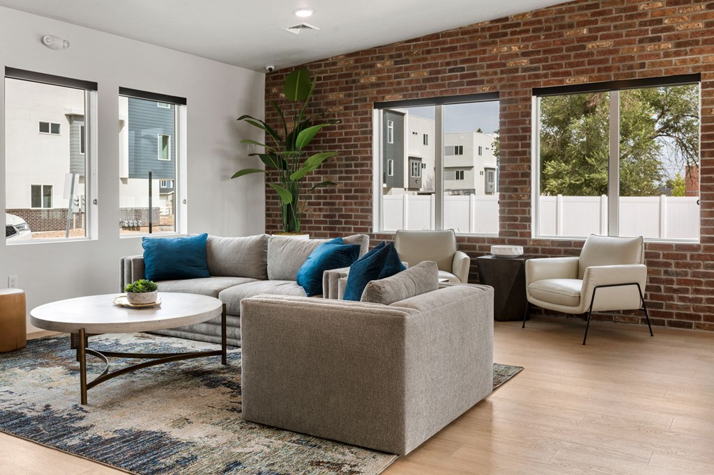 a living room with a brick wall and large windows