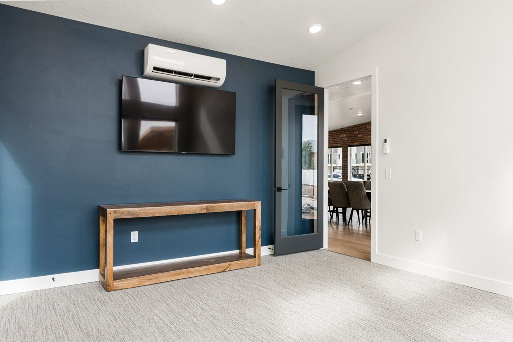a living room with a tv and a door to a dining room