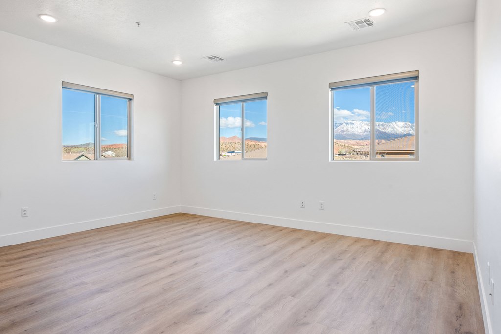 an empty living room with wood floors and white walls