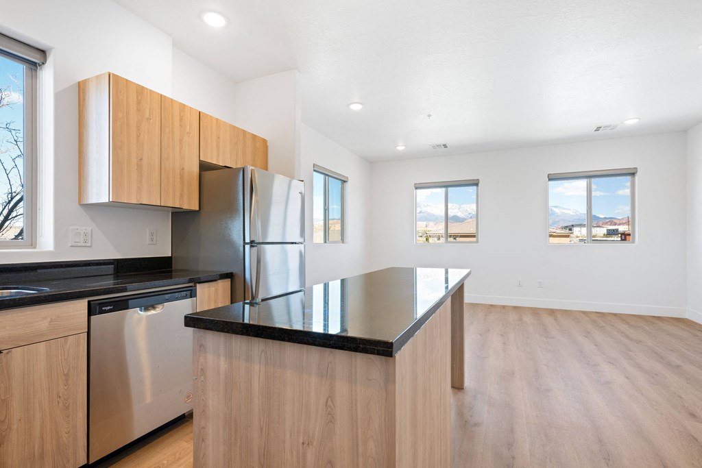 a kitchen with a large island and a stainless steel refrigerator