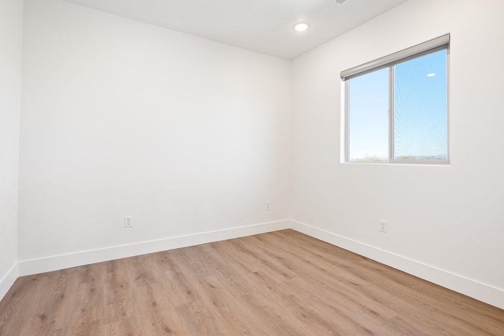 an empty room with wood floors and a window
