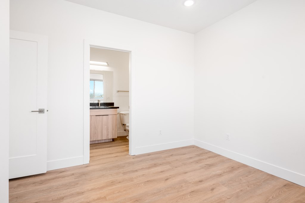 a living room with white walls and a wooden floor