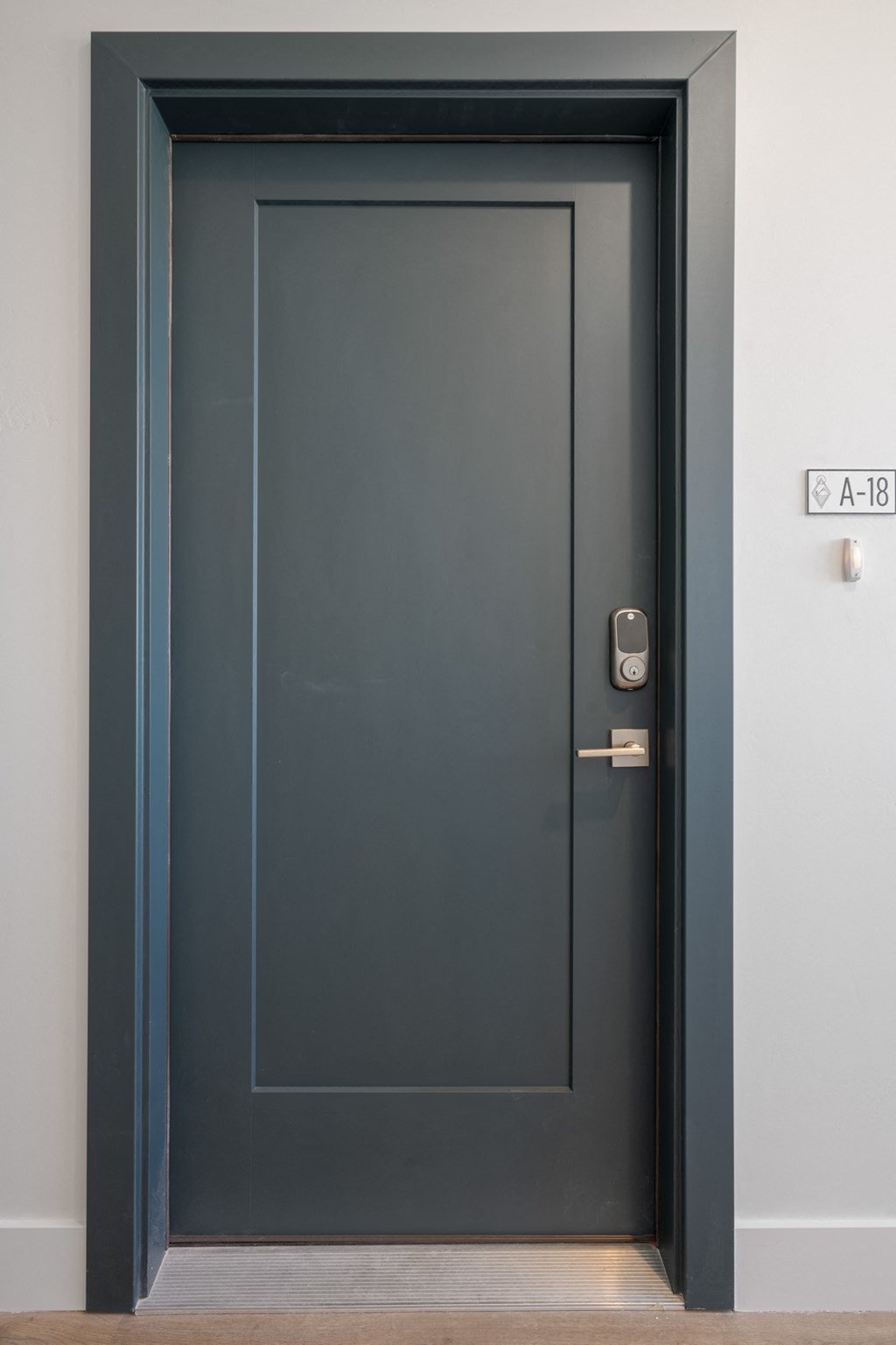 a black door with a silver door handle and a white wall
