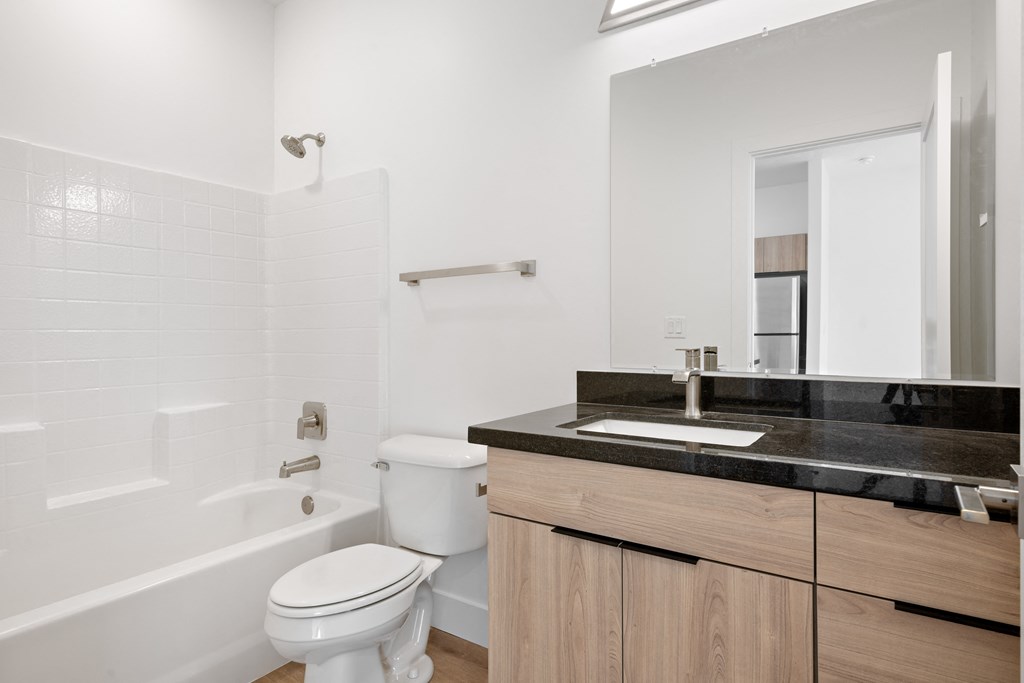 a bathroom with a toilet sink and tub and a mirror