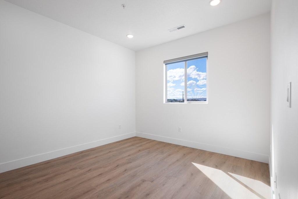 an empty room with white walls and a window