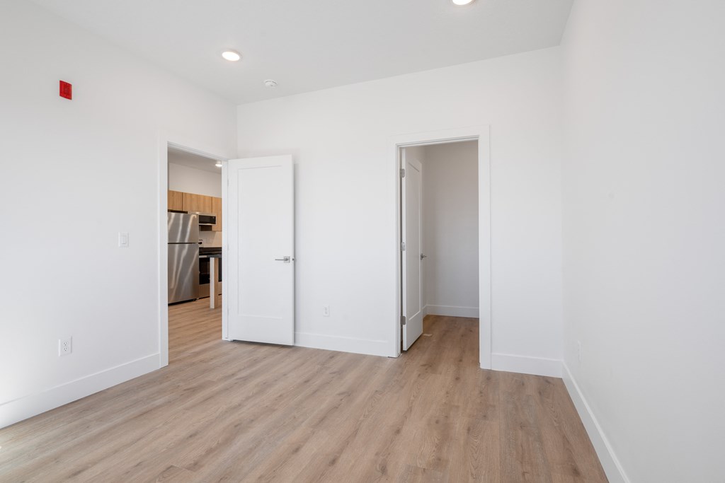 a renovated living room with white walls and wood flooring