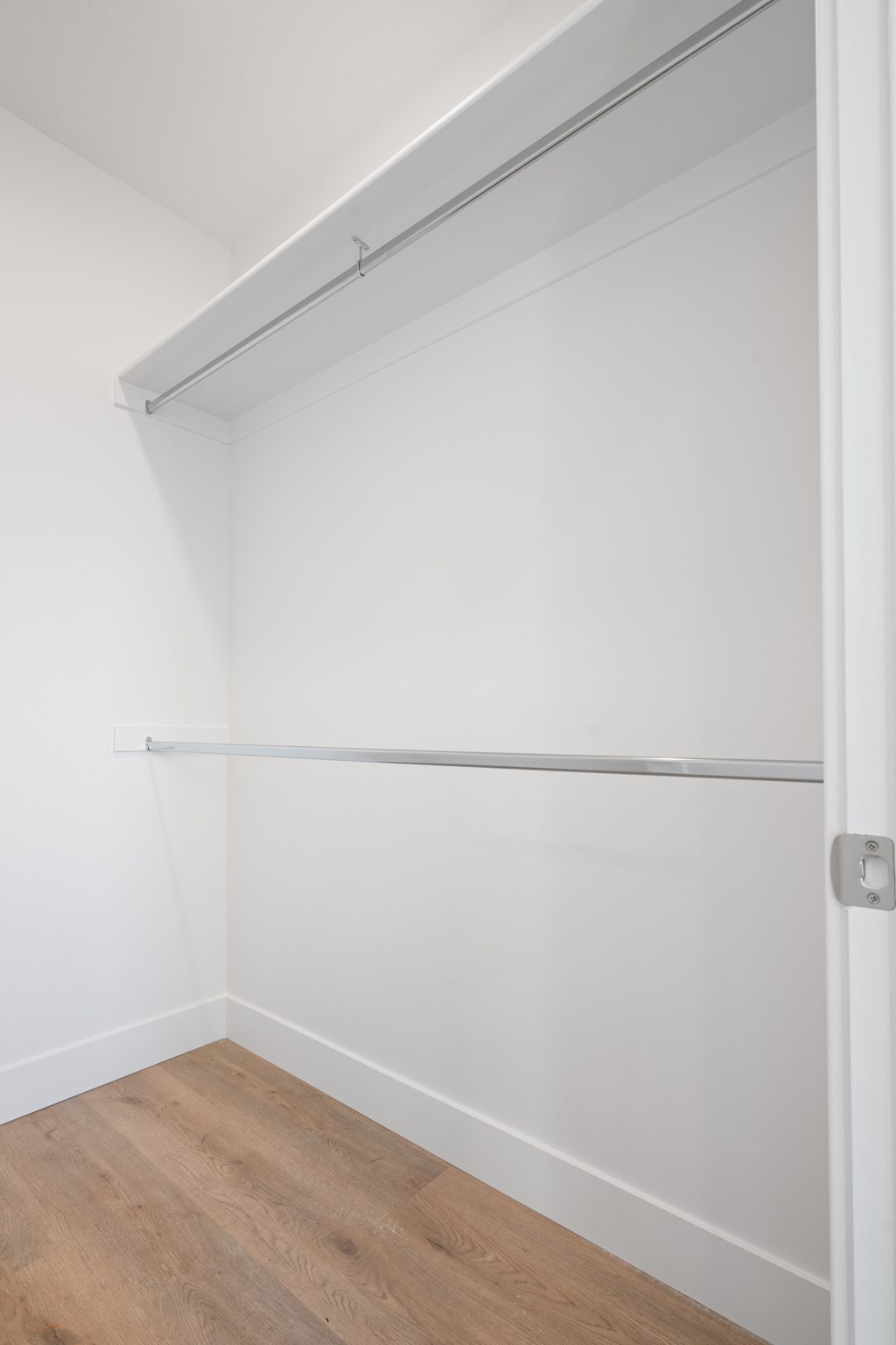 a room with white walls and a wooden floor and a white closet