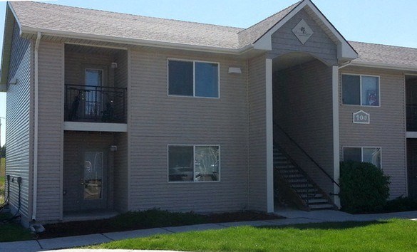 A two-story apartment building with a balcony on the second floor.