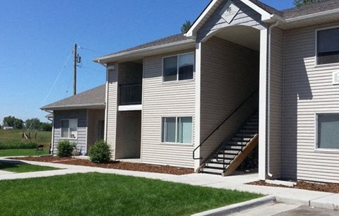 A house with a grey siding and a brown roof.