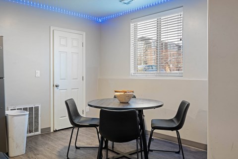 A dining room with a round table and four chairs.