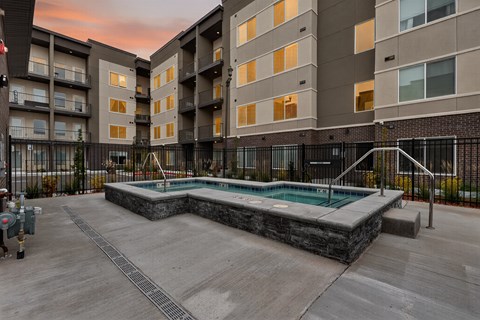 A swimming pool in a courtyard surrounded by apartment buildings.