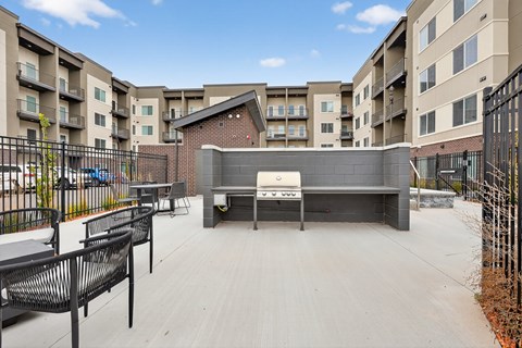 A black metal fence surrounds a patio with a table and chairs.