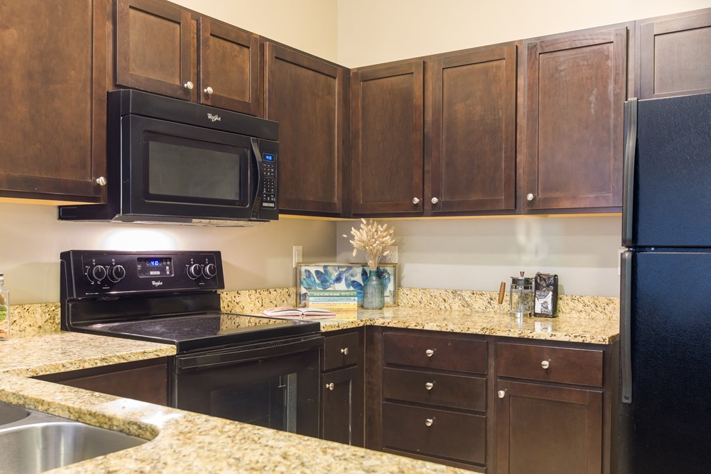 a kitchen with black appliances and granite counter tops at Sugar House Apartments By Urbana, Salt Lake City, UT, 84105