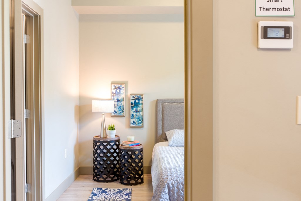a bedroom with a bed and a nightstand with a lamp at Sugar House Apartments By Urbana, Salt Lake City, UT, 84105