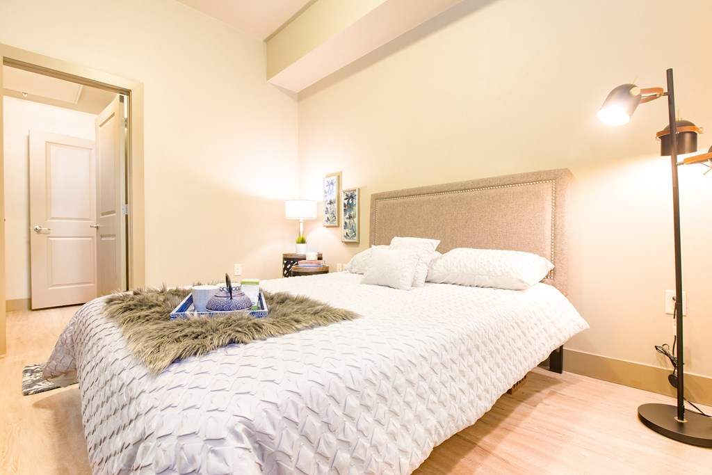 a bedroom with a large bed with a white comforter and pillows at Sugar House Apartments By Urbana, Salt Lake City, UT, 84105