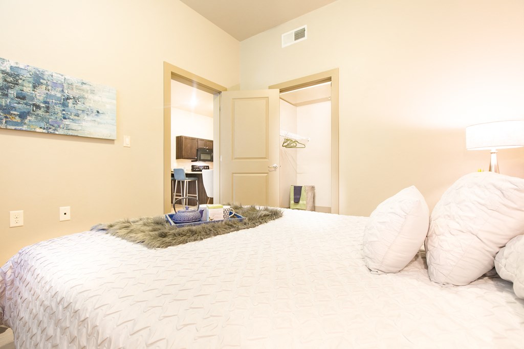 a bedroom with a large bed and a door to a bathroom at Sugar House Apartments By Urbana, Salt Lake City, UT, 84105
