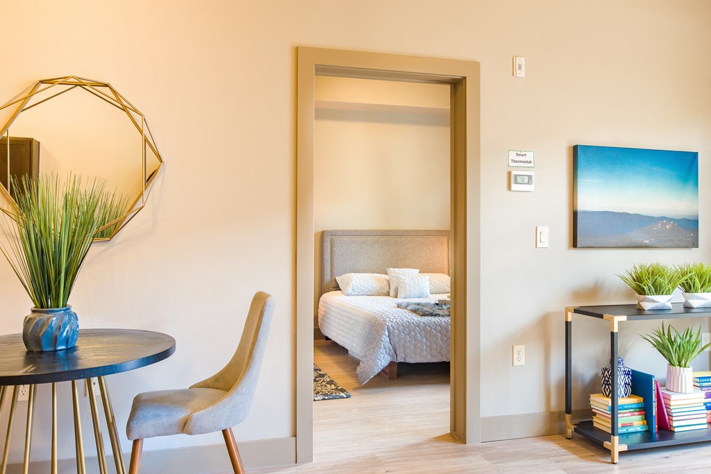 a bedroom with a bed and a table and a mirror at Sugar House Apartments By Urbana, Salt Lake City, UT, 84105