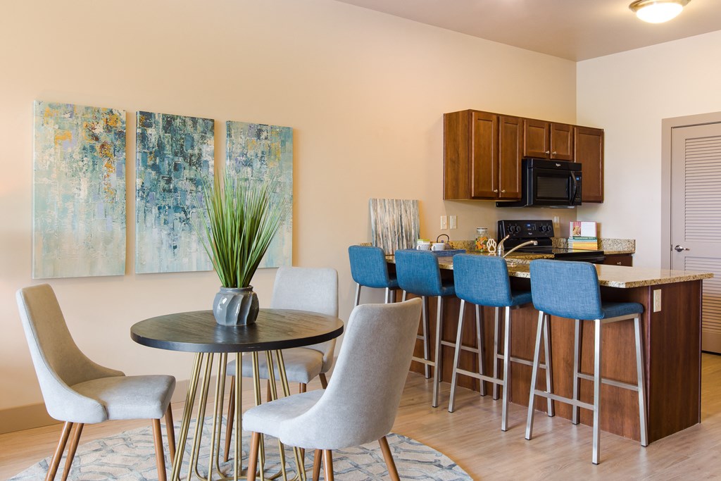 a dining room with a table and chairs and a kitchen at Sugar House Apartments By Urbana, Salt Lake City, UT, 84105