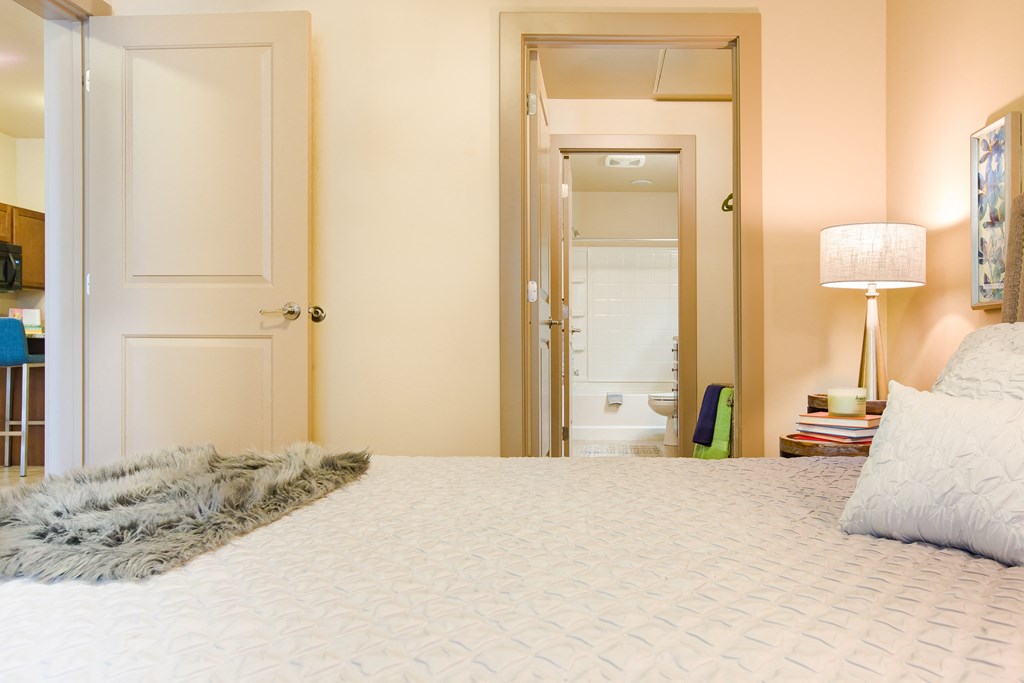 a bedroom with a large bed and a mirror in the closet at Sugar House Apartments By Urbana, Salt Lake City, UT, 84105