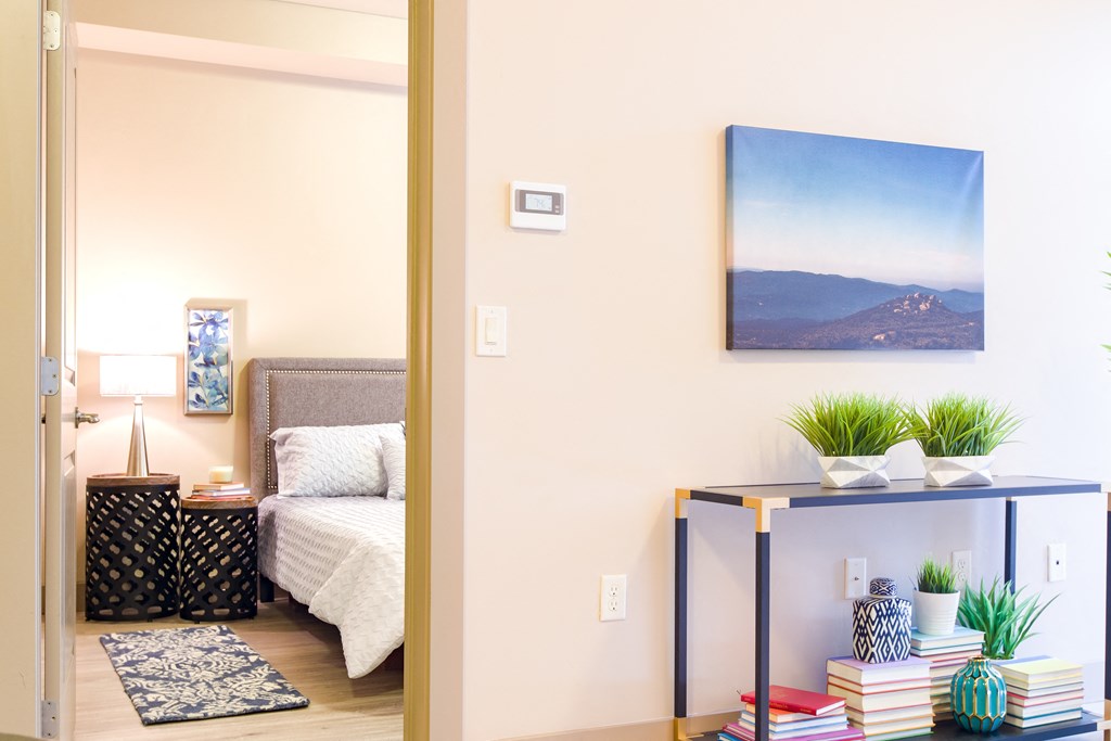 a bedroom with a bed and a table with plants at Sugar House Apartments By Urbana, Salt Lake City, UT, 84105