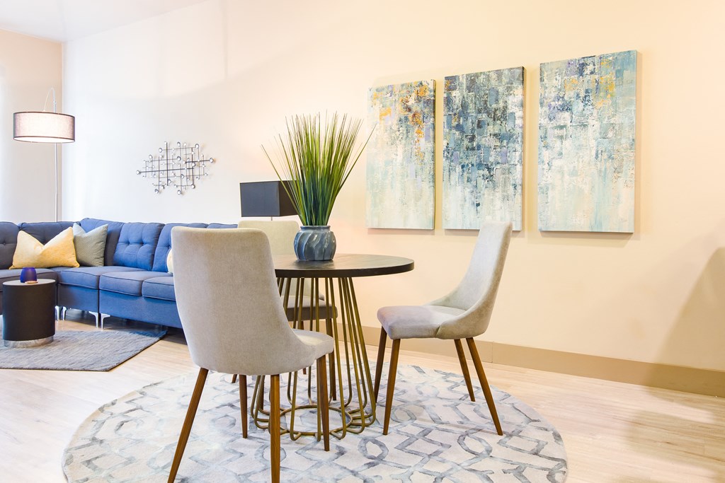 a living room with a table and chairs and paintings on the wall at Sugar House Apartments By Urbana, Salt Lake City, UT, 84105