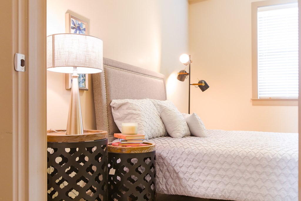 a bedroom with a bed and a nightstand with a lamp at Sugar House Apartments By Urbana, Salt Lake City, UT, 84105