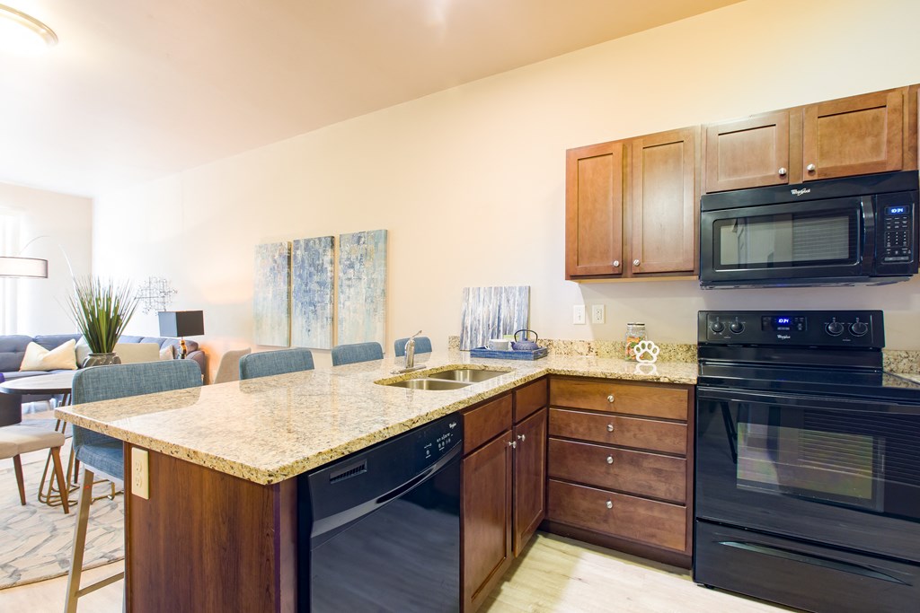 a kitchen with black appliances and a granite counter top at Sugar House Apartments By Urbana, Salt Lake City, UT, 84105