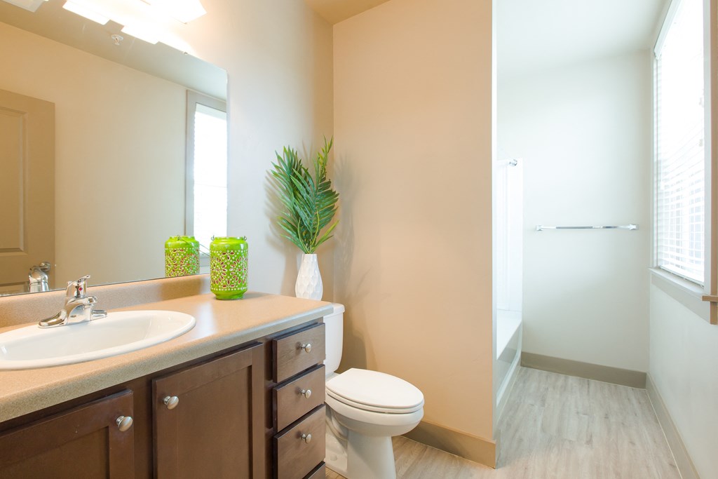 a bathroom with a toilet and a sink and a mirror at Sugar House Apartments By Urbana, Salt Lake City, UT, 84105