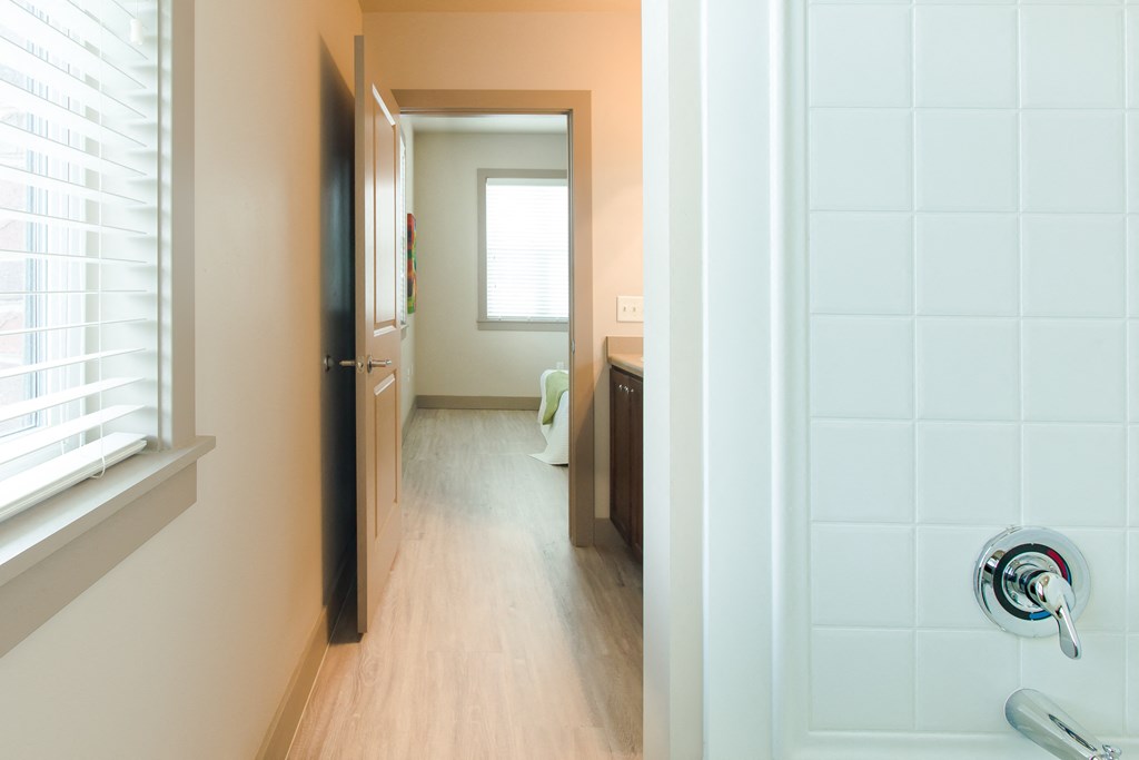 a view of a bathroom and a hallway with a door open at Sugar House Apartments By Urbana, Salt Lake City, UT, 84105