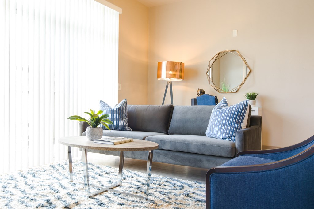a living room with a gray couch and blue chairs at Sugar House Apartments By Urbana, Salt Lake City, UT, 84105