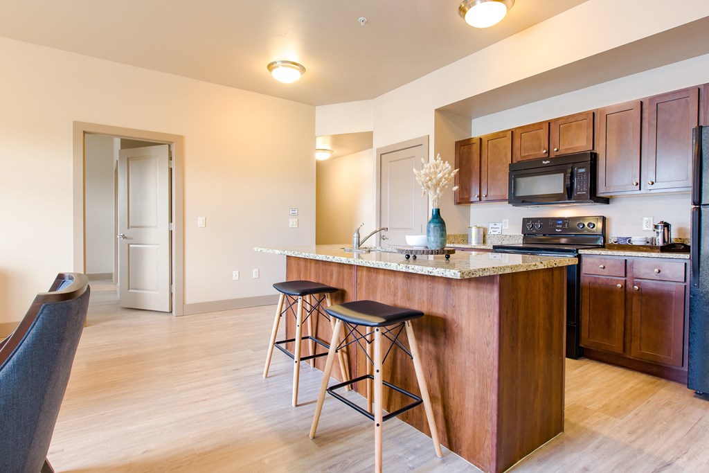 a kitchen with an island and stools at Sugar House Apartments By Urbana, Salt Lake City, UT, 84105