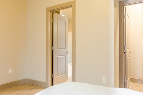 a bedroom with a white door and a white bed at Sugar House Apartments By Urbana, Salt Lake City, UT, 84105