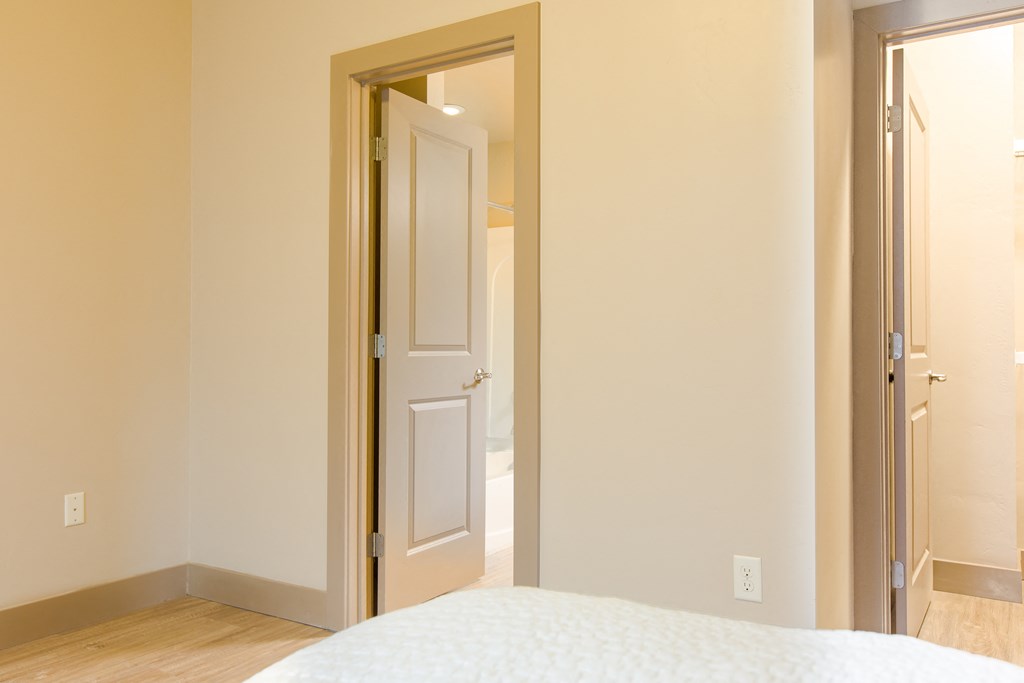 a bedroom with a white door and a white bed a bedroom with a white door and a white bed at Sugar House Apartments By Urbana, Salt Lake City, UT, 84105