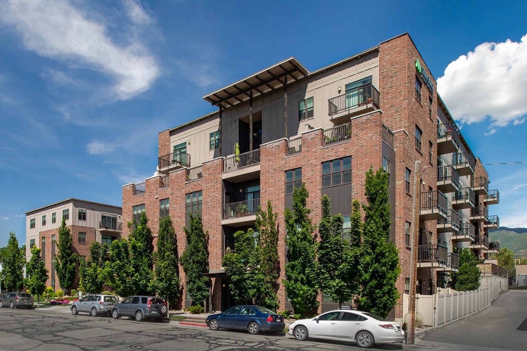 a view of the front of the building with cars parked in front and trees in front of at Sugar House Apartments By Urbana, Salt Lake City, UT, 84105