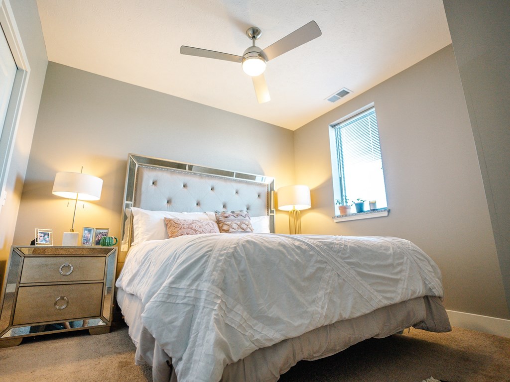 a bedroom with a bed and a ceiling fan