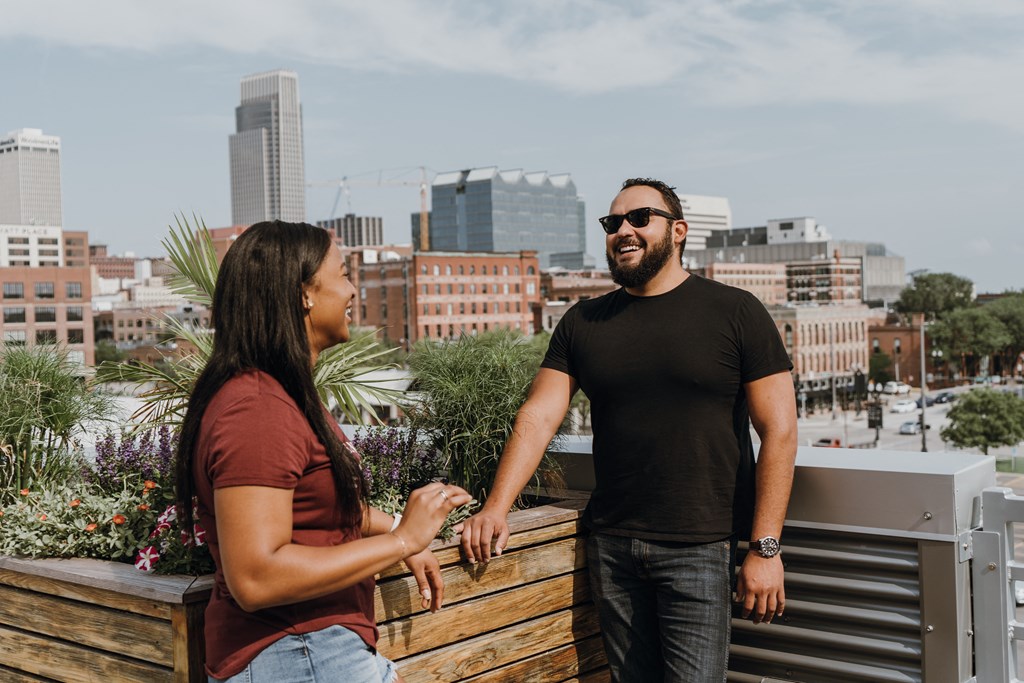 a man and a woman standing on a balcony overlooking the city