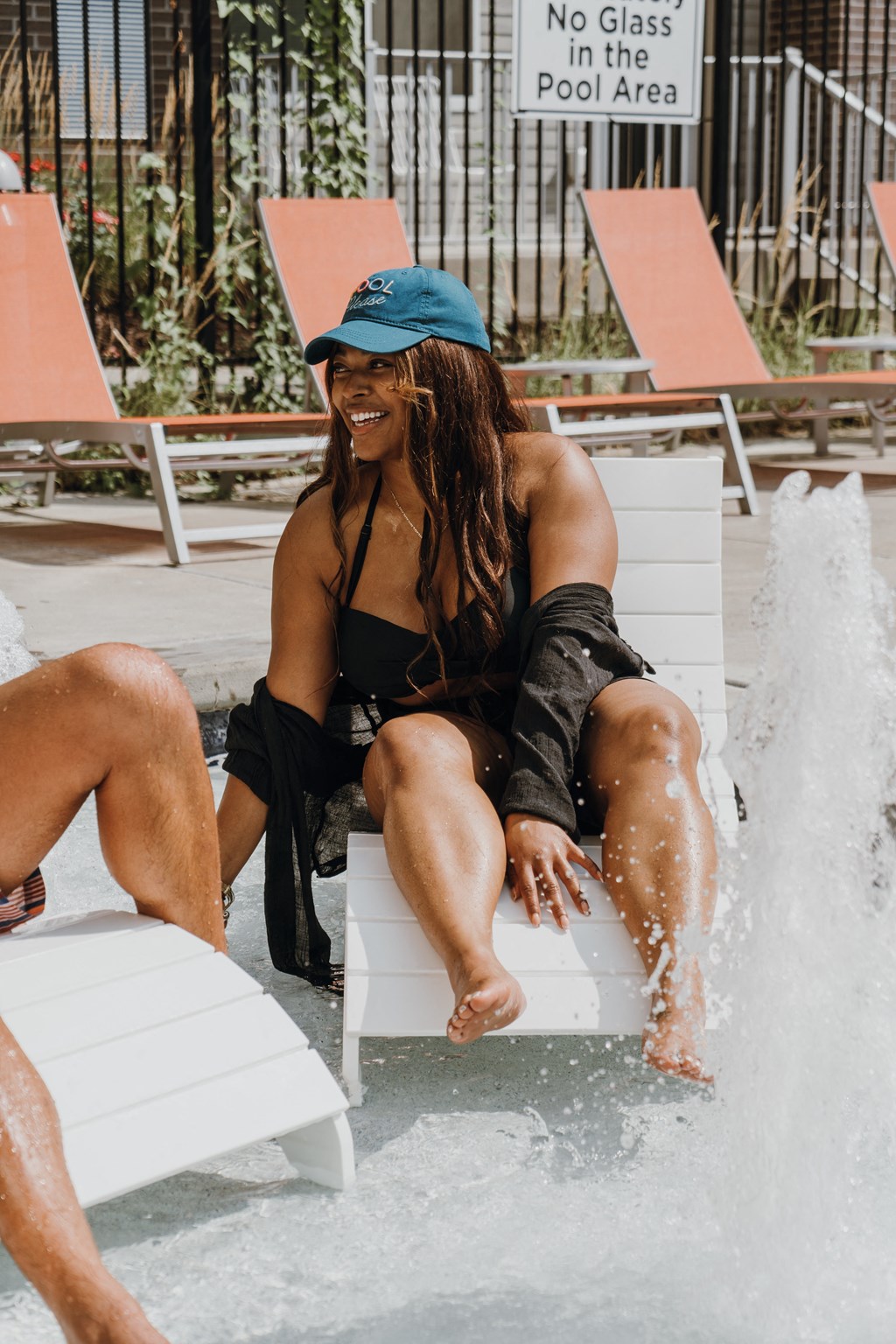 a woman sitting on a bench at a water fountain