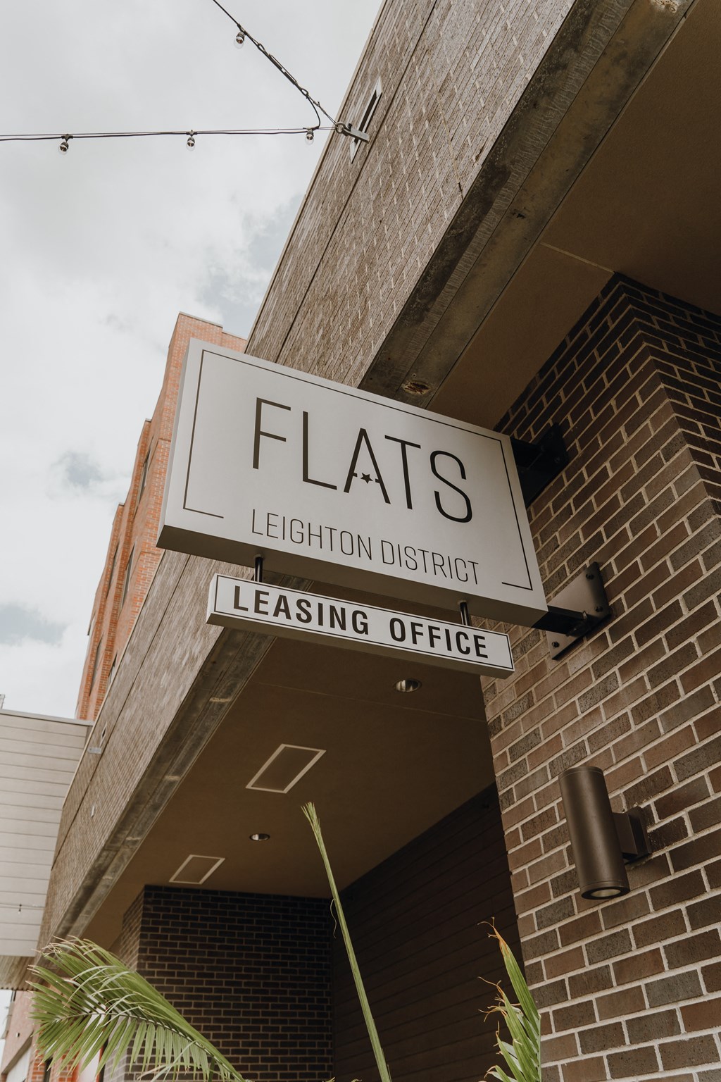 a leasing office sign on the side of a brick building