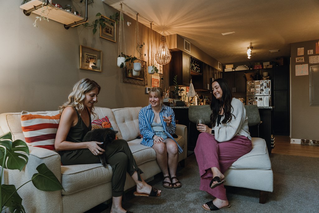 three women sitting on a couch in a living room