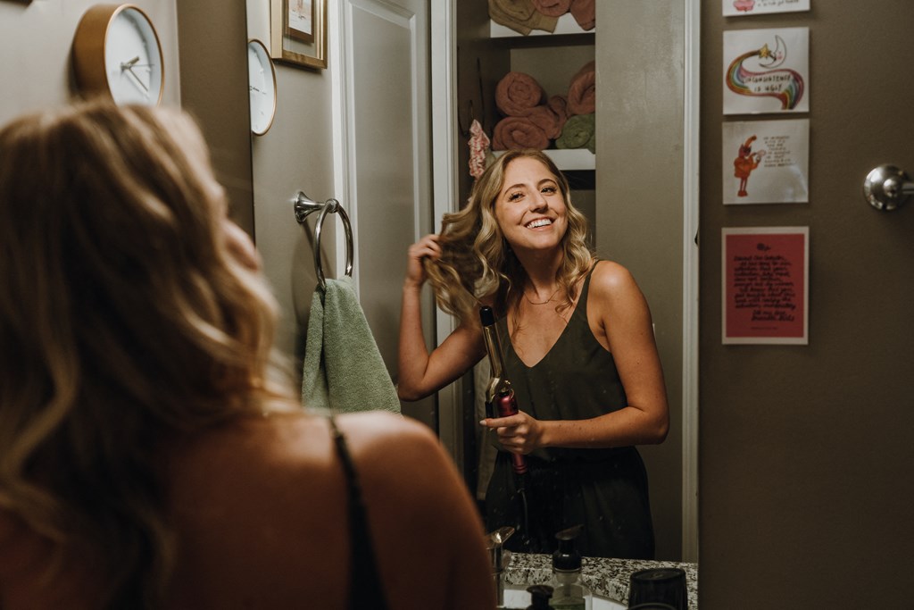 a woman brushing her hair in front of a mirror