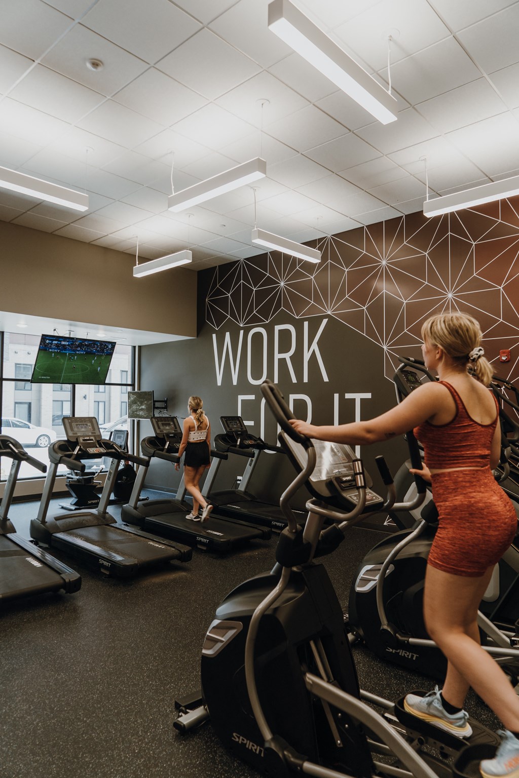 a woman running on a treadmill in a gym
