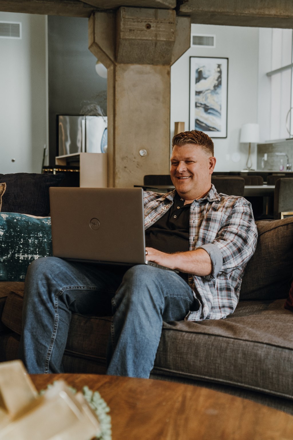 a man sitting on a couch using a laptop computer